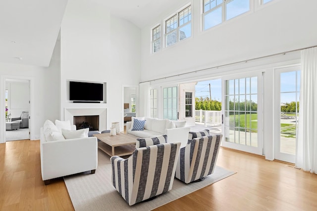 1 Fiske Ave, Westhampton Beach, NY 11978 - living area featuring light wood-type flooring, a towering ceiling, and a fireplace