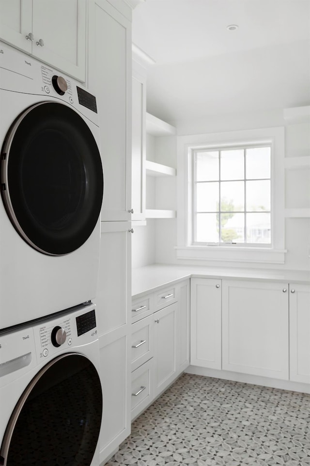 1 Fiske Ave, Westhampton Beach, NY 11978 - laundry area with cabinet space, stacked washer and clothes dryer, and light flooring