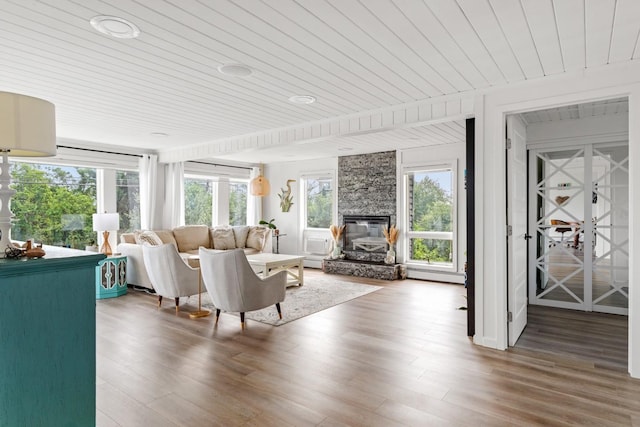 8 The Fairway, Oak Beach, NY 11702 - living area with wooden ceiling, healthy amount of natural light, a large fireplace, wood finished floors, and a baseboard radiator