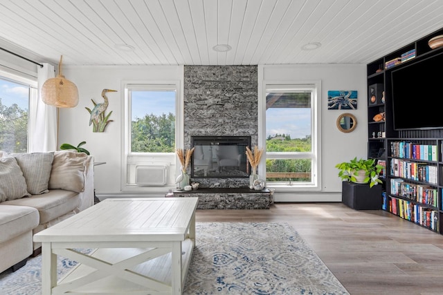 8 The Fairway, Oak Beach, NY 11702 - living area with wood ceiling, healthy amount of natural light, wood finished floors, a baseboard heating unit, and a fireplace