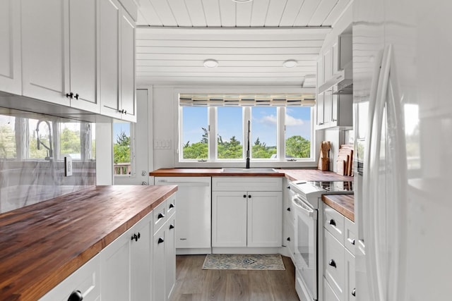 8 The Fairway, Oak Beach, NY 11702 - kitchen featuring butcher block counters, white appliances, healthy amount of natural light, and dark wood-style floors