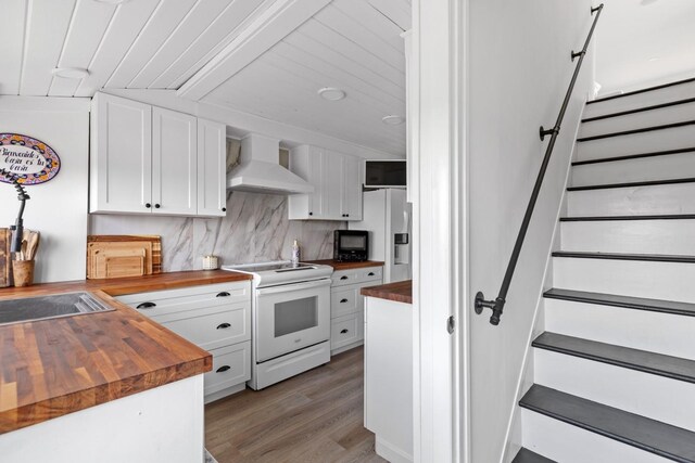 8 The Fairway, Oak Beach, NY 11702 - kitchen with butcher block countertops, white electric range, custom exhaust hood, refrigerator with ice dispenser, and light wood-type flooring