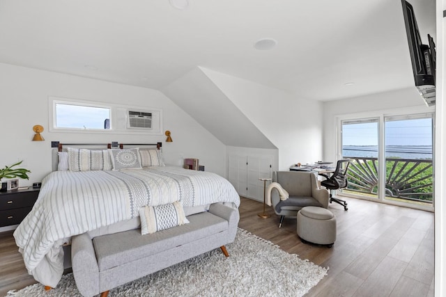 8 The Fairway, Oak Beach, NY 11702 - bedroom with wood finished floors, multiple windows, access to outside, and vaulted ceiling