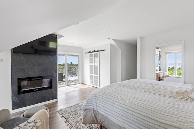 8 The Fairway, Oak Beach, NY 11702 - bedroom featuring access to exterior, wood finished floors, and a high end fireplace