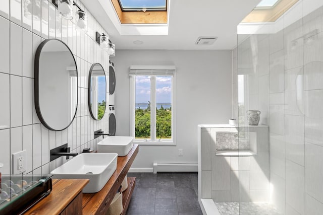 8 The Fairway, Oak Beach, NY 11702 - full bath featuring a baseboard radiator, a skylight, tiled shower, double vanity, and tile patterned flooring