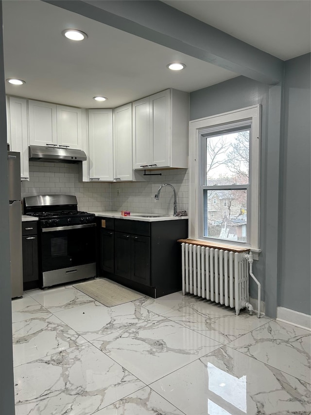 68 Ramapo Rd, Garnerville, NY 10923 - kitchen with gas stove, radiator, tasteful backsplash, under cabinet range hood, and white cabinetry