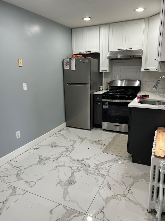 68 Ramapo Rd, Garnerville, NY 10923 - kitchen with gas stove, under cabinet range hood, freestanding refrigerator, light countertops, and white cabinetry