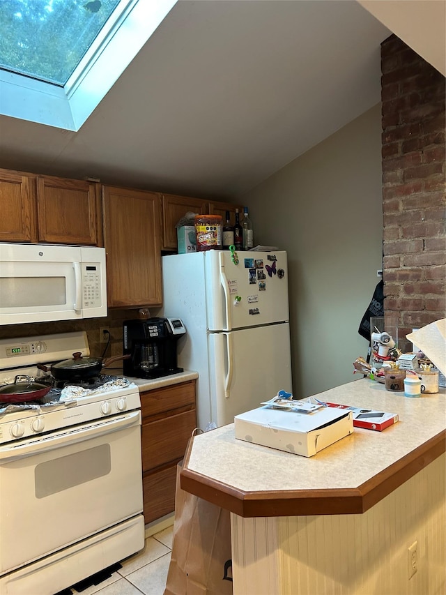 68 Ramapo Rd, Garnerville, NY 10923 - kitchen featuring white appliances, light countertops, a skylight, and light tile patterned floors