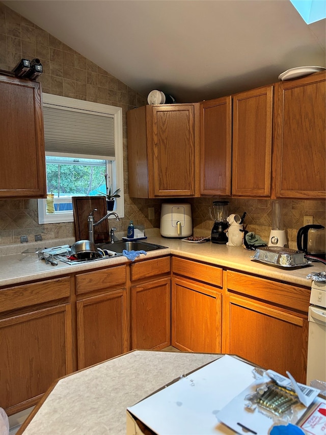 68 Ramapo Rd, Garnerville, NY 10923 - kitchen with light countertops, decorative backsplash, brown cabinetry, and vaulted ceiling