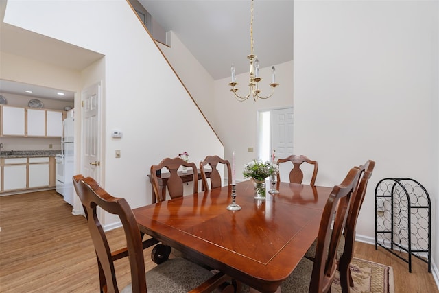 79 Meadow Way, Hopewell Junction, NY 12533 - dining room featuring light wood-style flooring, a chandelier, and a towering ceiling