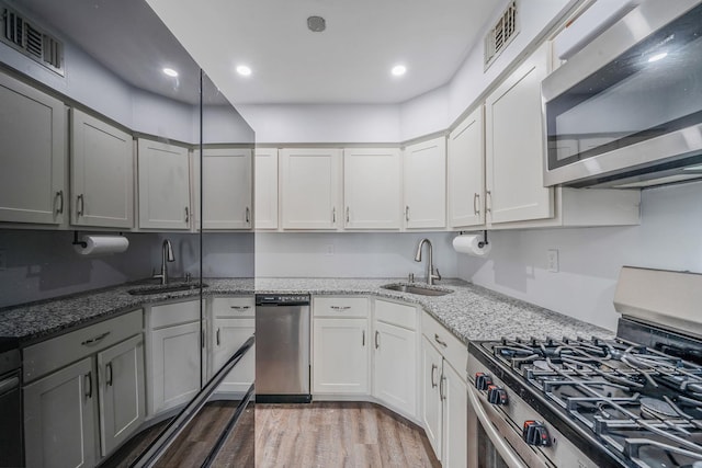 77 Fairview Cir Unit 77, Middle Island, NY 11953 - kitchen with stainless steel appliances, light stone countertops, light wood-style flooring, gray cabinetry, and recessed lighting