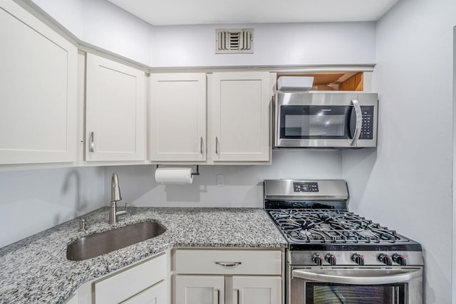 77 Fairview Cir Unit 77, Middle Island, NY 11953 - kitchen featuring stainless steel appliances, white cabinetry, and light stone countertops