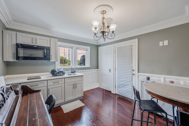 557 Newbridge Rd, East Meadow, NY 11554 - kitchen featuring black microwave, a chandelier, ornamental molding, dark wood-style floors, and a wainscoted wall