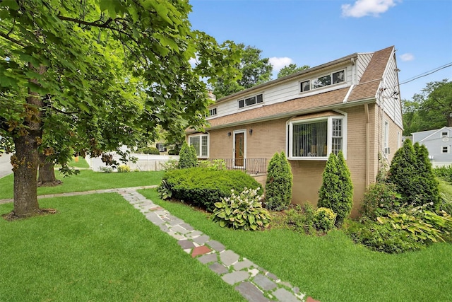 98 N Evarts Ave, Elmsford, NY 10523 - view of front of house featuring brick siding, a front yard, and roof with shingles