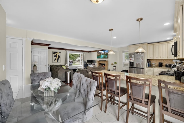 98 N Evarts Ave, Elmsford, NY 10523 - dining room with a lit fireplace, light tile patterned flooring, and recessed lighting