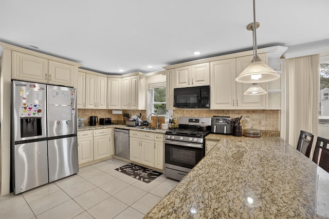 98 N Evarts Ave, Elmsford, NY 10523 - kitchen featuring cream cabinetry, appliances with stainless steel finishes, light tile patterned floors, backsplash, and light stone countertops
