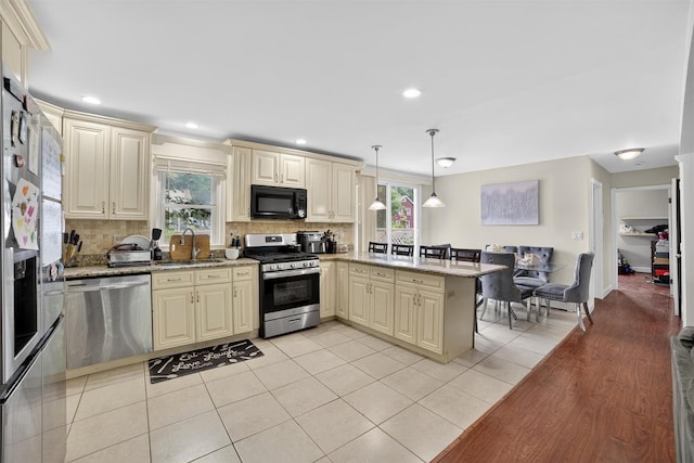 98 N Evarts Ave, Elmsford, NY 10523 - kitchen featuring appliances with stainless steel finishes, cream cabinets, a peninsula, backsplash, and recessed lighting