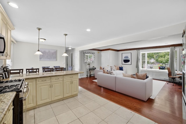 98 N Evarts Ave, Elmsford, NY 10523 - kitchen with cream cabinetry, stainless steel appliances, light tile patterned flooring, open floor plan, and a peninsula