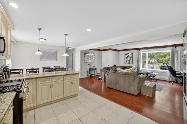 98 N Evarts Ave, Elmsford, NY 10523 - kitchen featuring cream cabinetry, appliances with stainless steel finishes, light tile patterned floors, hanging light fixtures, and open floor plan