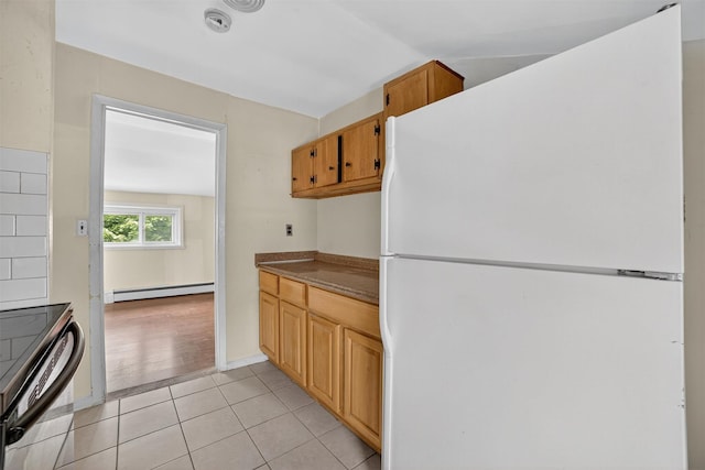 98 N Evarts Ave, Elmsford, NY 10523 - kitchen with freestanding refrigerator, light tile patterned floors, a baseboard heating unit, vaulted ceiling, and dark countertops