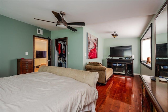 137 Jefferson St, Inwood, NY 11096 - bedroom with dark wood-style floors, a walk in closet, a barn door, a closet, and a ceiling fan