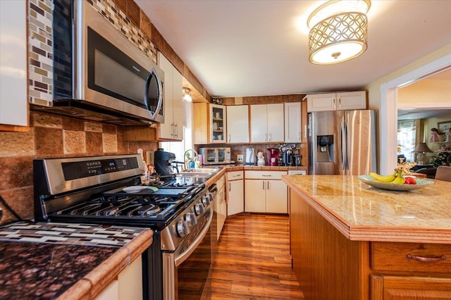 137 Jefferson St, Inwood, NY 11096 - kitchen with appliances with stainless steel finishes, healthy amount of natural light, wood finished floors, and decorative backsplash