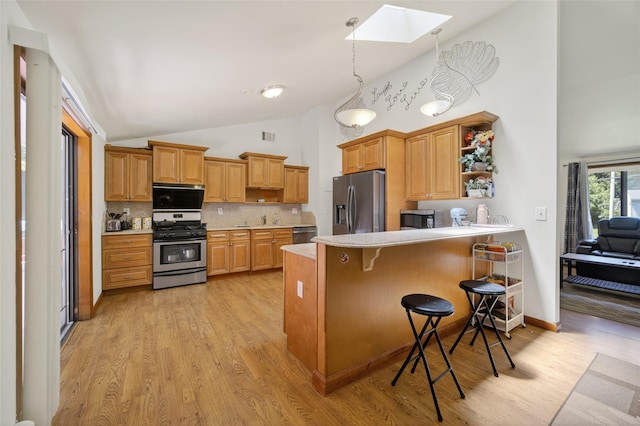 49 Raker Rd, Poughkeepsie, NY 12603 - kitchen featuring appliances with stainless steel finishes, a skylight, high vaulted ceiling, light wood-style flooring, and light countertops