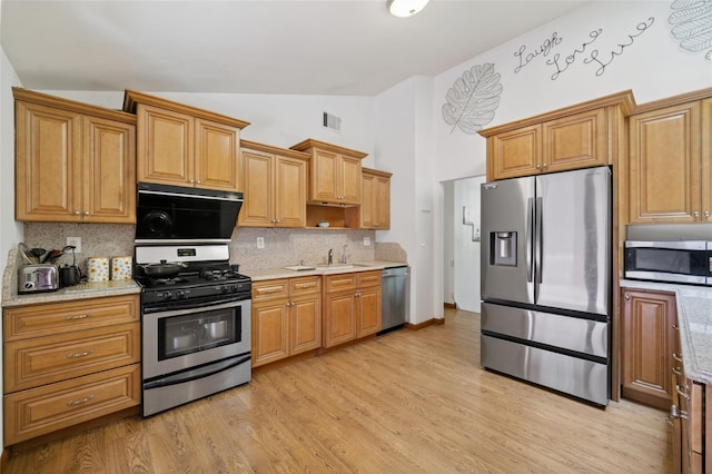49 Raker Rd, Poughkeepsie, NY 12603 - kitchen featuring appliances with stainless steel finishes, decorative backsplash, light wood-style flooring, high vaulted ceiling, and light stone counters