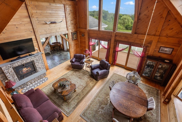 17 Conover Way, Lagrangeville, NY 12540 - living area featuring wood-type flooring, wooden walls, a fireplace, and a high ceiling