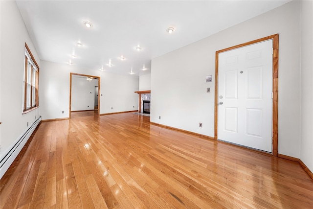 2162 24th St, Astoria, NY 11105 - unfurnished living room with a baseboard radiator, light wood finished floors, and a tile fireplace