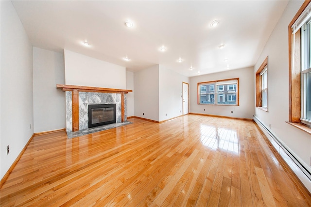 2162 24th St, Astoria, NY 11105 - unfurnished living room with a baseboard radiator, light wood finished floors, a high end fireplace, and recessed lighting