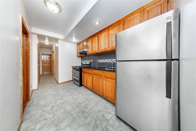 2162 24th St, Astoria, NY 11105 - kitchen featuring stainless steel appliances, dark countertops, decorative backsplash, brown cabinetry, and under cabinet range hood