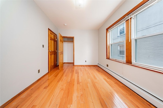 2162 24th St, Astoria, NY 11105 - unfurnished room featuring a baseboard heating unit and light wood finished floors
