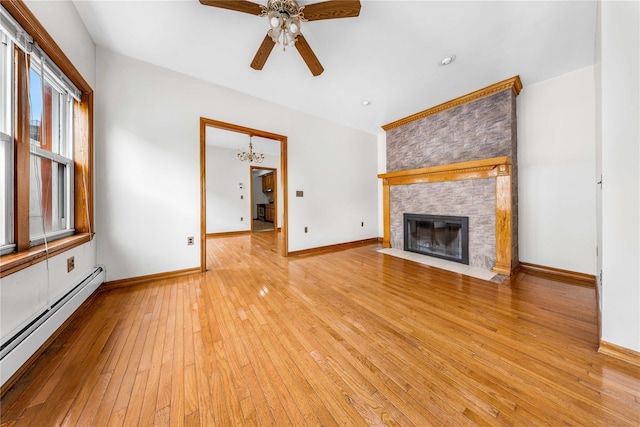 2162 24th St, Astoria, NY 11105 - unfurnished living room featuring a baseboard radiator, light wood-style flooring, ceiling fan, a large fireplace, and a chandelier