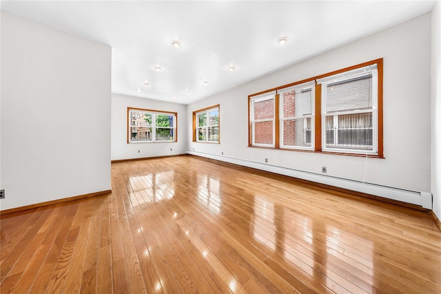 2162 24th St, Astoria, NY 11105 - empty room featuring a baseboard heating unit and light wood finished floors