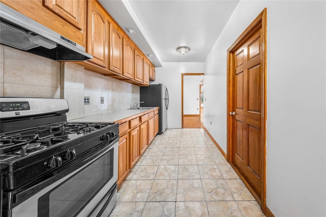 2162 24th St, Astoria, NY 11105 - kitchen featuring stainless steel appliances, extractor fan, light countertops, decorative backsplash, and brown cabinets