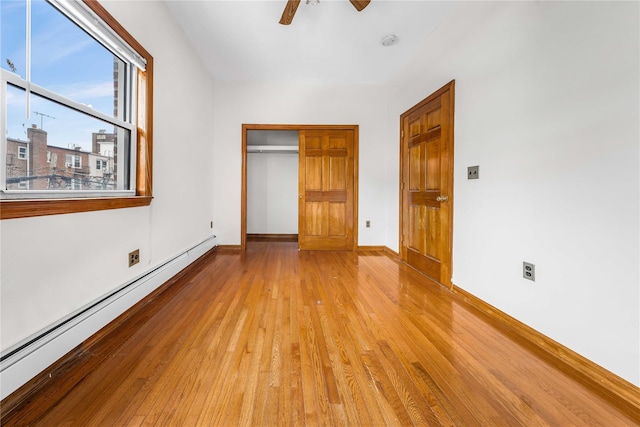 2162 24th St, Astoria, NY 11105 - unfurnished bedroom with a baseboard radiator, light wood-type flooring, a closet, and ceiling fan