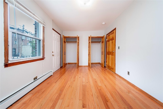 2162 24th St, Astoria, NY 11105 - unfurnished bedroom with a baseboard heating unit and light wood-style flooring