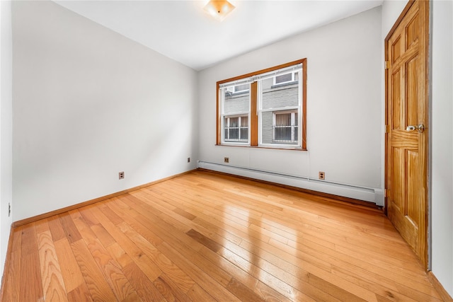 2162 24th St, Astoria, NY 11105 - empty room with a baseboard heating unit and light wood finished floors