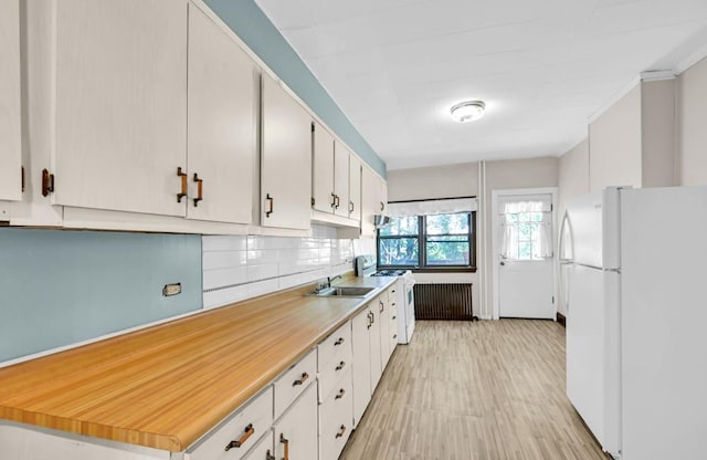 29 William St, Ossining, NY 10562 - kitchen featuring white appliances, tasteful backsplash, light countertops, light wood finished floors, and white cabinetry