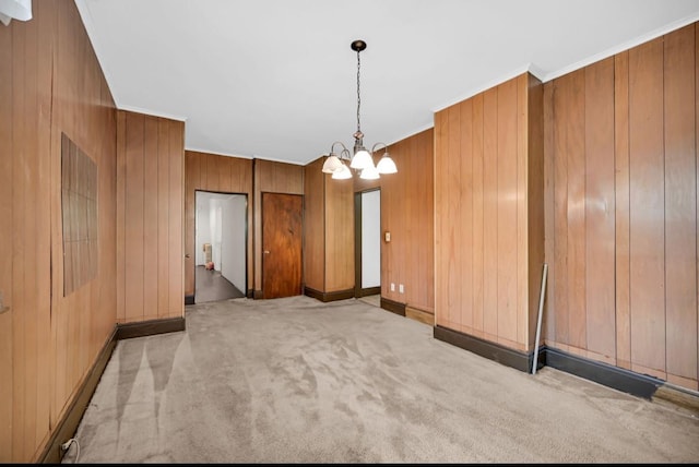 29 William St, Ossining, NY 10562 - spare room featuring a chandelier, light colored carpet, wooden walls, and crown molding