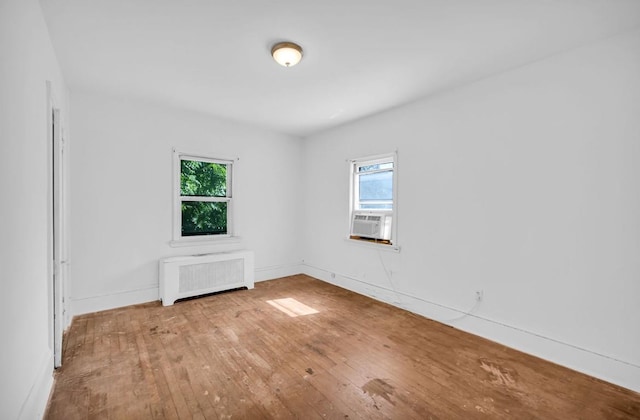 29 William St, Ossining, NY 10562 - unfurnished room featuring radiator heating unit, healthy amount of natural light, and hardwood / wood-style flooring