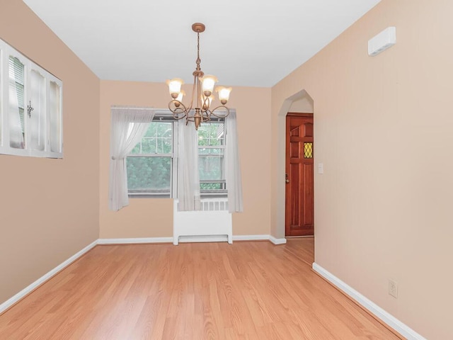3227 Bruckner Blvd, Bronx, NY 10461 - unfurnished dining area with light wood-style flooring, a chandelier, and arched walkways