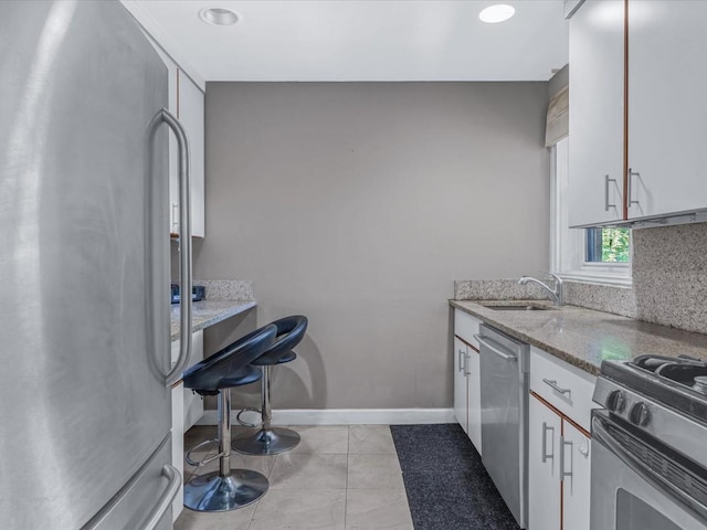 42-30 Douglaston Pkwy Unit 3L, Douglaston, NY 11363 - kitchen featuring appliances with stainless steel finishes, white cabinets, light stone countertops, recessed lighting, and light tile patterned floors
