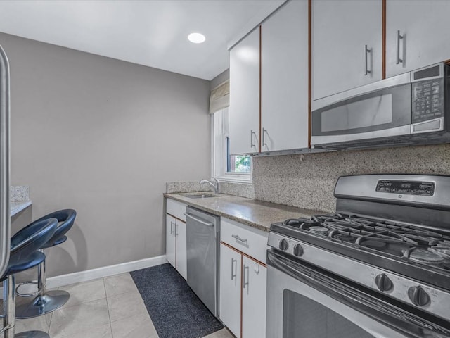 42-30 Douglaston Pkwy Unit 3L, Douglaston, NY 11363 - kitchen with appliances with stainless steel finishes, light tile patterned flooring, and white cabinetry