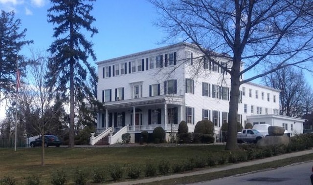 42-30 Douglaston Pkwy Unit 3L, Douglaston, NY 11363 - colonial-style house featuring covered porch and a front lawn