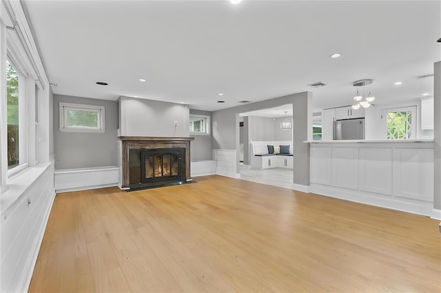 8 W Ln, South Salem, NY 10590 - unfurnished living room featuring light wood-style flooring, a fireplace with flush hearth, recessed lighting, and a chandelier
