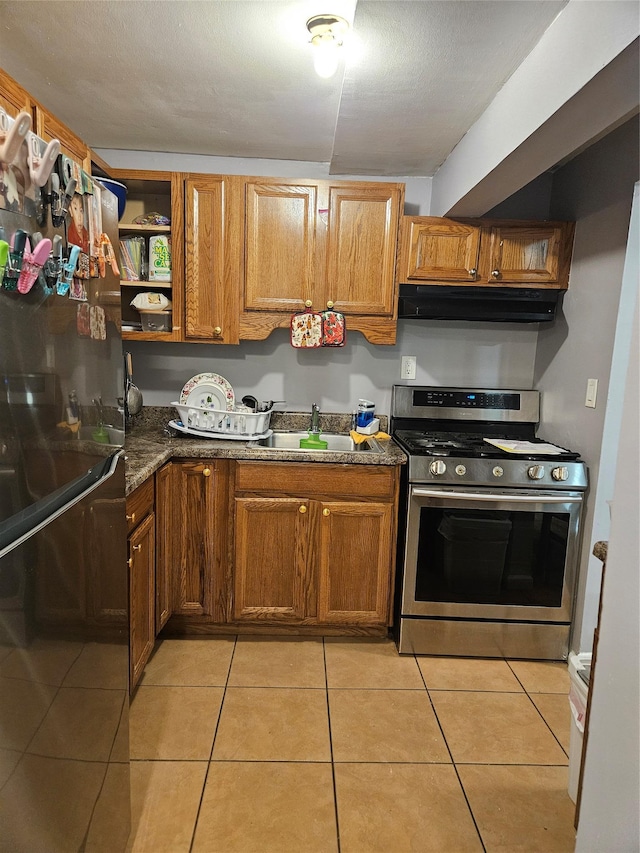 78 Carmine Dr Unit D14, Wappingers Falls, NY 12590 - kitchen with stainless steel gas range oven, under cabinet range hood, light tile patterned floors, freestanding refrigerator, and brown cabinetry