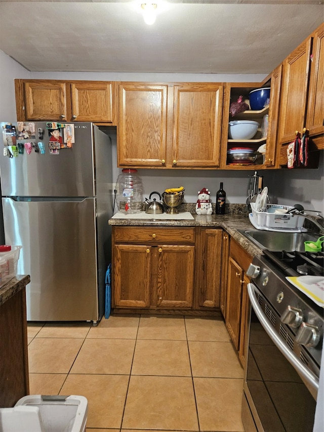 78 Carmine Dr Unit D14, Wappingers Falls, NY 12590 - kitchen with appliances with stainless steel finishes, light tile patterned floors, and brown cabinets