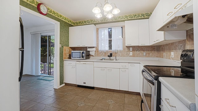 70 Wilson Ave, Mastic Beach, NY 11951 - kitchen with stainless steel appliances, under cabinet range hood, light countertops, a chandelier, and white cabinets